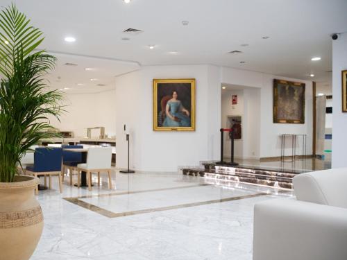 a living room with a potted plant in the middle at Hotel Pasarela in Seville