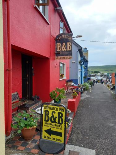 a red building with a bbc sign in front of it at Baywatch Inn in Dingle