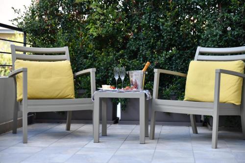 two chairs and a table with a glass of wine at Hotel Villa MIKI in Bordighera