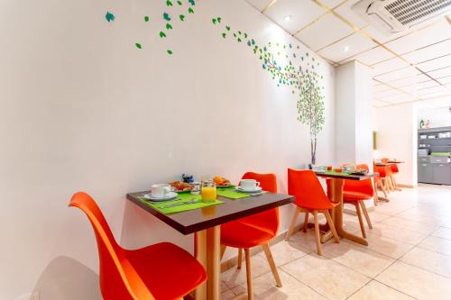 a dining room with red chairs and a table at Hotel Provencal in Saint-Raphaël