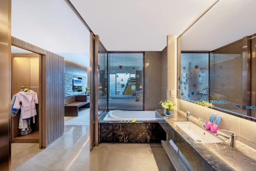 a bathroom with a tub and a sink at Mission Hills Hotel Resorts Dongguan in Dongguan