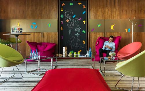 a man sitting in a red chair in a room at Radisson Blu Hotel, Abu Dhabi Yas Island in Abu Dhabi