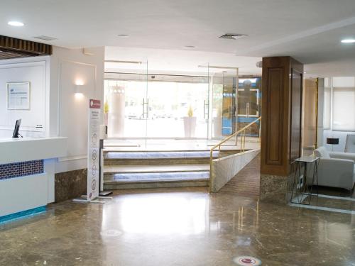 a lobby with a staircase and a glass door at Hotel Pasarela in Seville