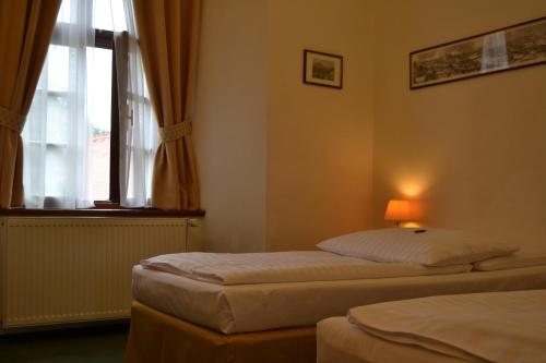 two beds in a room with a window at Adalbert Ecohotel in Prague