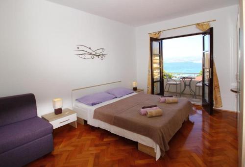 a bedroom with a large bed and a couch at Apartments Dubreta in Cavtat