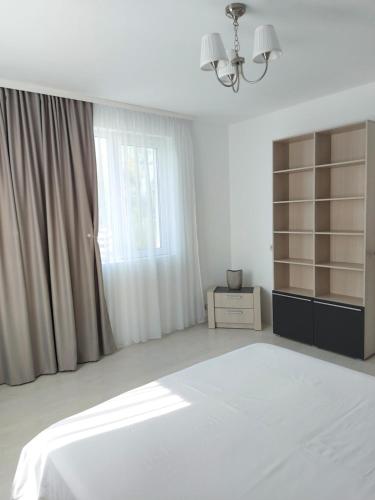 a white bedroom with a bed and a window at Villa Romelia - Select Apartments in Vadu
