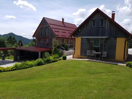 a house with a lawn in front of it at Apartments Za Grapo in Cerkno