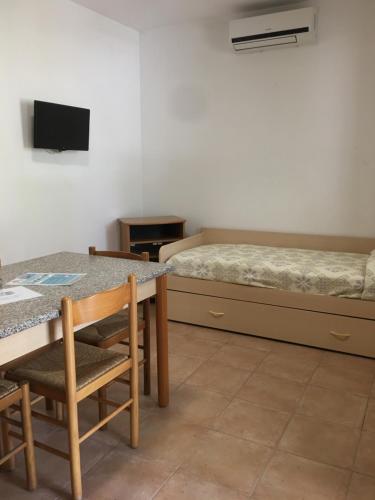 a room with a bed and a table and chairs at Residence Alba in Vieste