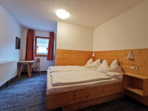 a bedroom with a bed with a wooden headboard at Karlingerhof in Achenkirch