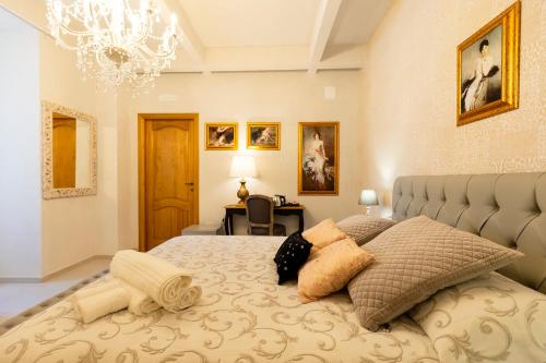 a bedroom with a large bed with a chandelier at Palazzo Badiale history&rooms in Atella