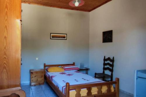 ein Schlafzimmer mit einem Bett, einem Tisch und einem Stuhl in der Unterkunft Feli's country house in Argalasti