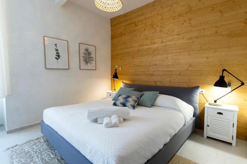 a bedroom with a large bed with a wooden wall at Palazzo Badiale history&rooms in Atella
