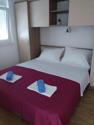 a bedroom with a large bed with towels on it at Apartmani Petra in Olib