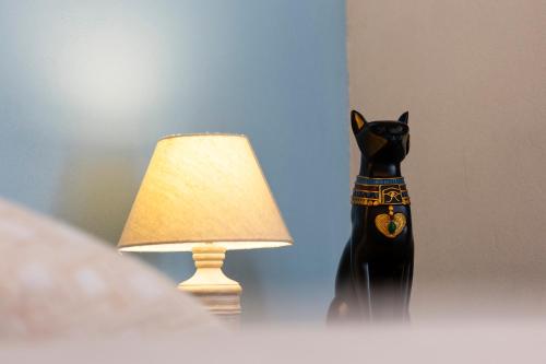 a statue of a black cat next to a lamp at Palazzo Badiale history&rooms in Atella