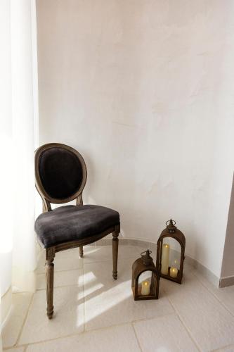 a chair and two lights in a room at Palazzo Badiale history&rooms in Atella