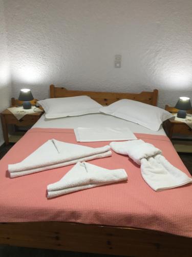 a bed with white towels and pillows on it at Chaliotis Apartments in Lefkandi Chalkidas