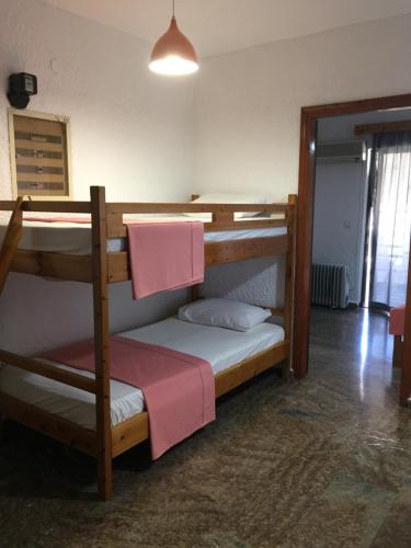 sypialnia z 2 łóżkami piętrowymi i różowym ręcznikiem w obiekcie Chaliotis Apartments w mieście Chalkida
