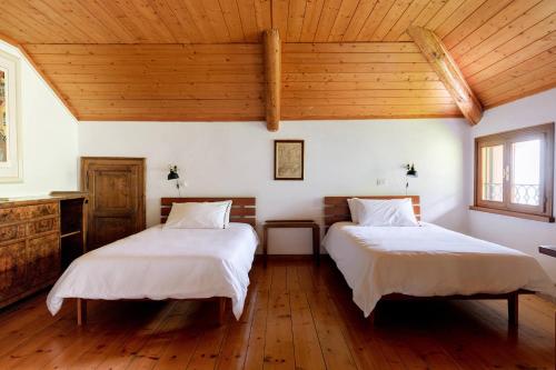 Duas camas num quarto com tectos em madeira em Fondazione Lucia De Conz 