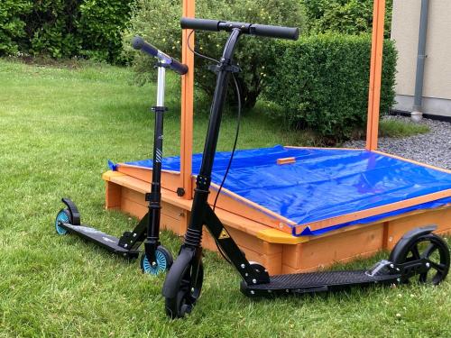 a scooter parked in the grass next to a boat at Gîte La Clef des Champs in Libin