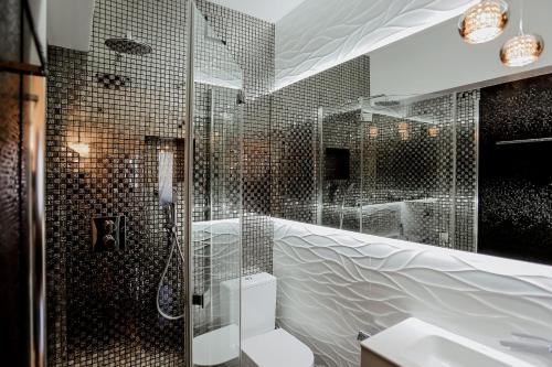 a bathroom with a shower with a toilet and a sink at Apartament Royal in Łomża