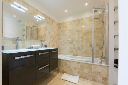 uma casa de banho com uma banheira, um lavatório e um chuveiro em Fully equipped appartment 105 m2 clear view on the sea and californie hills em Cannes