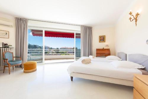 Fully equipped appartment 105 m2 clear view on the sea and californie hills في كان: غرفة نوم بسريرين ونافذة كبيرة