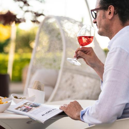 a man sitting at a table with a glass of wine at Hotel Borgo Brianteo in Ponte San Pietro