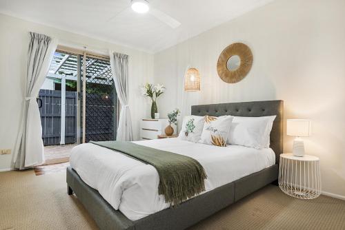 a bedroom with a large bed and a window at Spacious Family Beach House in Caloundra