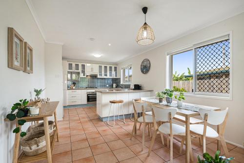 a kitchen and dining room with a table and chairs at Spacious Family Beach House in Caloundra