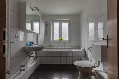 y baño con bañera, lavabo y aseo. en Ferienhäuser Bergfreiheit en Winterberg