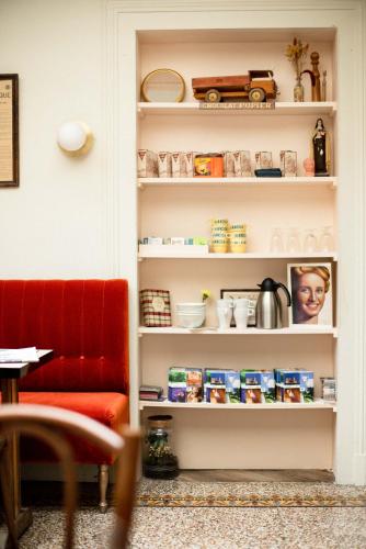 a book shelf with food and a red chair at Maison Séraphine - Guest house - Bed and Breakfast in Laon