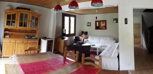 - un salon avec un canapé, une table et des chaises dans l'établissement LE BOIS JOLI Chalet 4 étoiles CLEDICIHOME Cadre paisible en lisière de forêt, à Gérardmer