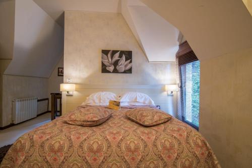 a bedroom with a large bed with two pillows at Ioana Hotel in Sinaia