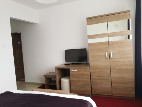 una camera da letto con cassettiera, TV e letto di Sport Avalanche a Ranca