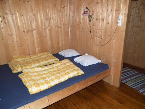 two beds in a room with a wooden wall at Haukedalen Hytter in Viksdalen