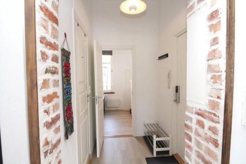 a hallway with white walls and a brick wall at Nordic Host - Frogner - Well appointed 2 Bedroom in Lovely West Side Neighborhood in Oslo