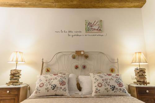a bedroom with a white bed with two lamps at Hotel CineApollo - Ogni camera un film! in Messina