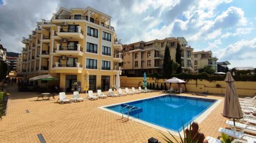 a hotel with a swimming pool in front of a building at Horizon Katrina Apartments - Sea line & Beach Access in Sveti Vlas