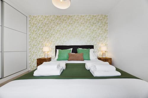 1 dormitorio con 1 cama blanca grande con almohadas verdes en Lanzarote Blue Senator, en Costa Teguise