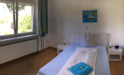 a bedroom with a bed with a blue towel on it at Ferienidylle Oberschützen in Oberschützen