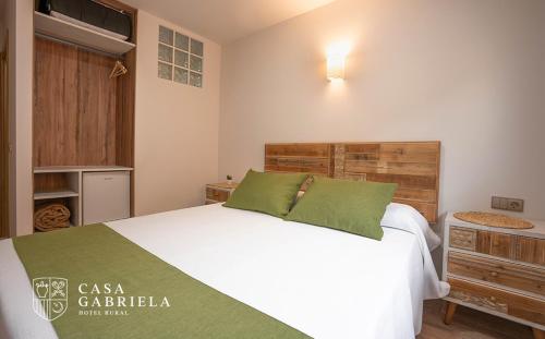 a bedroom with a large white bed with green pillows at Casa Gabriela Hotel in Jiménez de Jamuz