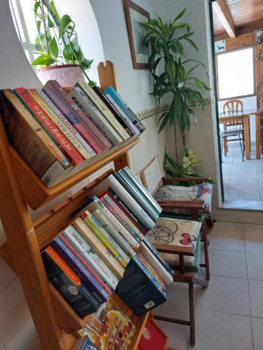 a stack of books on a wooden shelf at Guest House Capitao Mor in Faro