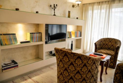 a living room with a tv and a table and chairs at Garni Hotel TIANIS in Kotor