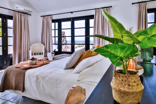 una camera da letto con un grande letto bianco e una pianta di Sea Star Lanzarote a Playa Blanca