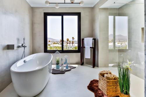 un bagno con una grande vasca e una grande finestra di Sea Star Lanzarote a Playa Blanca