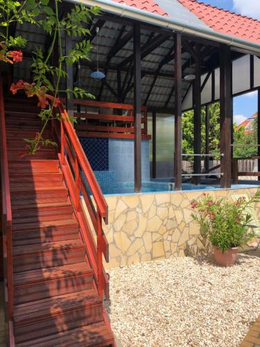 a wooden staircase leading to a house with a pool at RELAX Apartman in Nyíregyháza