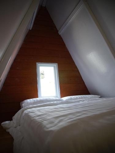 a bedroom with a white bed and a window at GSV Cottage Sharia in Bogor