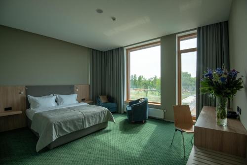 Una habitación de hotel con una cama y un jarrón de flores. en SHAMBALA WELLNESS CLUB, en Rozhny