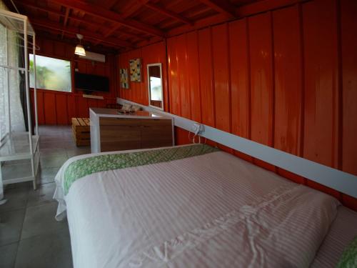 a bedroom with a bed and a red wall at GSV Cottage Sharia in Bogor