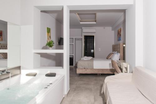 a bedroom with a bed and a bathroom with a tub at Denise Beach Hotel in Laganas